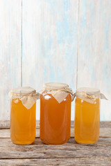 Kombucha tea in glass canister on wooden background