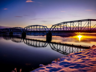 bridge over river at sunset
