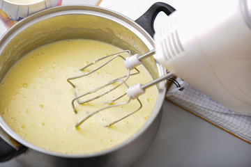 Fototapeta premium An electric mixer stirs and whips the dough to bake a pie.