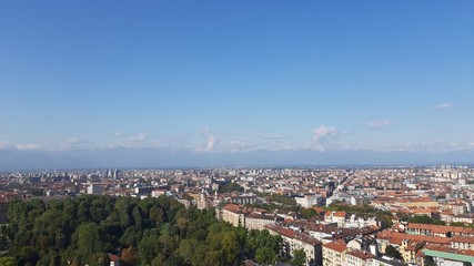 Fototapeta na wymiar Turin, Italy - 01/004/2019: Beautiful panoramic view from Mole Antoneliana to the city of Turin in winter days with clear blue sky and the alps in the background. 