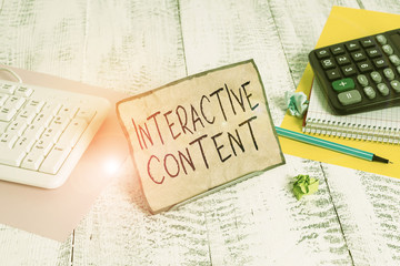 Text sign showing Interactive Content. Business photo showcasing It requires the participants active engagement Notepaper stand on buffer wire in between computer keyboard and math sheets