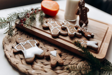 painted gingerbread man Christmas gingerbread cookies lie on a wooden board.