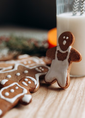 painted gingerbread man Christmas gingerbread cookies lie on a wooden board.