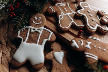 Naklejka premium painted gingerbread man Christmas gingerbread cookies lie on a wooden board.