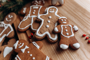 painted gingerbread man Christmas gingerbread cookies lie on a wooden board.
