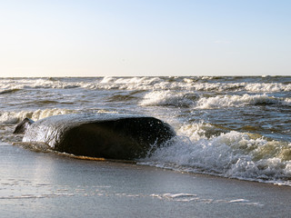 backlit landscape with stony sea shore