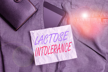 Text sign showing Lactose Intolerance. Business photo text digestive problem where body is unable to digest lactose Smartphone device inside trousers front pocket with wallet and note paper