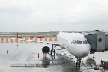 Plane in airport terminal. Service work of checking aircraft. Boarding at the airport.