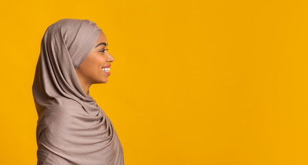 Profile portrait of smiling black muslim girl in hijab