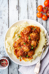 Meatballs in tomato sauce with mashed potato on the white plate, top view, view from above