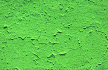 Old peeling paint on the wall. Green abstract background. Beautiful green textured stucco on the wall. Background from green stucco.
