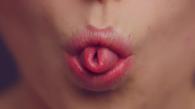 woman tongue rolling her tongue into U shape,close up