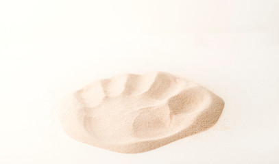 A lot of dry beach sand on white background, hand