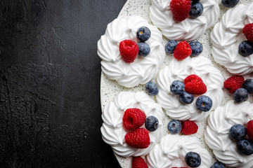 White meringues cakes with berries, raspberry and blueberry. Flat lay, top view