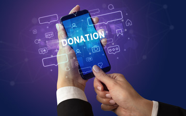Female hand typing on smartphone with DONATION inscription, social media concept