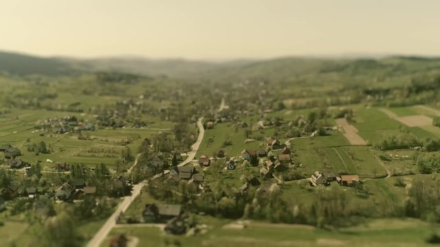 Dreamy, fantasy tiny model village. Aerial footage of typical Polish village with tilt-shift lens effect for shallow depth of field.