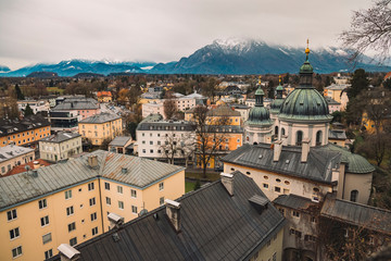 Fototapeta na wymiar old European city Salzburg in Austria urban top view landmark with living buildings and cathedral church foreground, snowy peaks of Alps mountain ridge landscape background scenic view