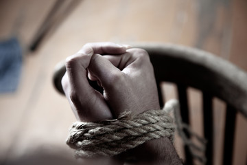 man hands tied on dark background