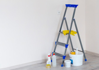 a stepladder with paint cans and tools in a bright renovated room with a copy of the space
