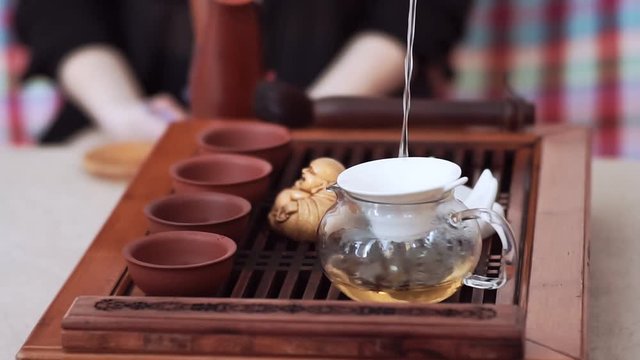 Through a sieve in the kettle pour delicious tea and pour it into cups. Tea ceremony