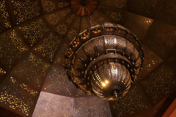 Traditional Moroccan lantern from 1001 night hanging from the ceiling in a building in Marrakesh, Morocco