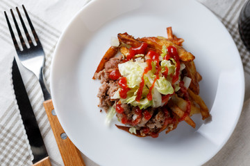 Traditional cuban potatoes with minced meat, lettuce and onion