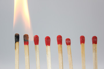 row if matches being lit by flame  in a chain reaction