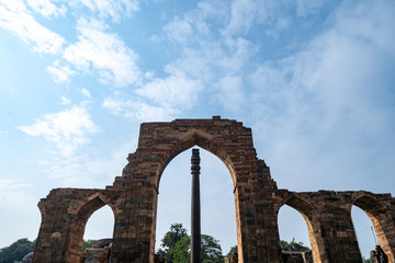 Famous iron pillar frame with ruins at the Qutub Minar complex in New Delhi India. Negative space...