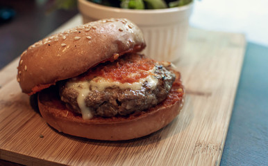 A hamburger on wooden tray