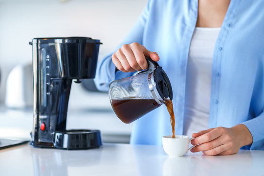Woman using coffee maker for making and brewing coffee at home. Coffee blender and household kitchen appliances for makes hot drinks