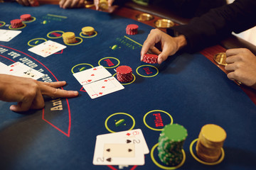 Hands of players and croupiers in the game cards