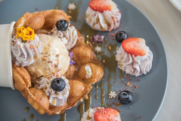 Honeycomb sweets, ice cream and cream adorned with strawberries and berries