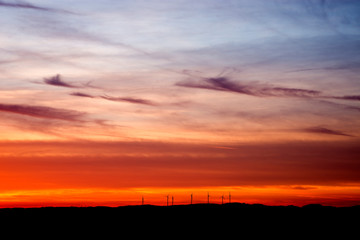 Roter sonnenuntergang vor einem windpark