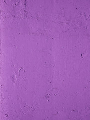 Old peeling paint on the wall. Beautiful purple textured stucco on the wall. Background from purple stucco.