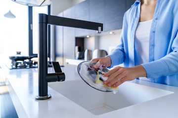 Cleaning woman dishwashing during housework