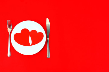 Valentine's Day background. Heart on plate with fork and knife. Flat lay, top view, copy space.