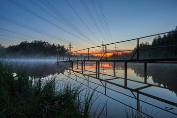 Metal construction on the background of power lines at sunset