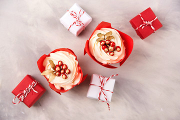 Christmas cupcakes and gifts on modern background, top view. Christmas card with holiday cupcakes
