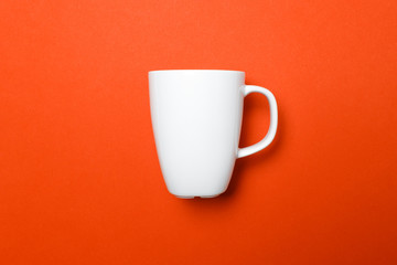 Weiße Kaffeetasse von der Seite auf roten Hintergrund mit leichten Schatten