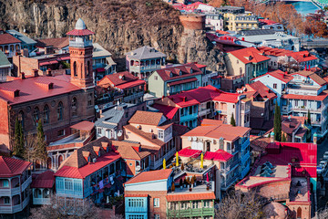 Panorama of traditional colorful houses with wooden colored carved balconies and red roof tiles in the old town of Tbilisi, Georgia - obrazy, fototapety, plakaty
