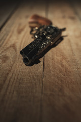 Historic revolver pistol on old wooden floor.