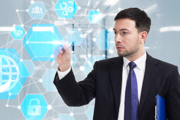 Obraz premium Business, Technology, Internet and network concept. Young businessman working on a virtual screen of the future and sees the inscription: Transformation