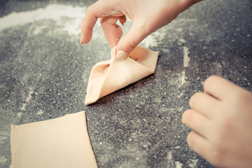 hands of the girl sculpts pies from the dough