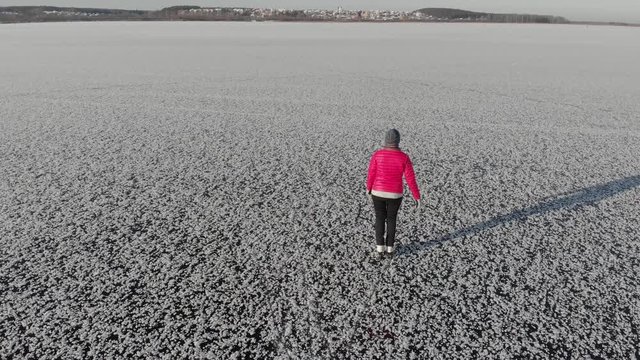Girl ice skating roll on a frozen huge pond. View from above. Snc with a quadcopter