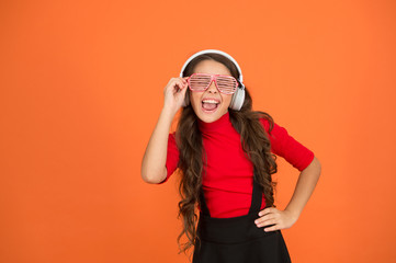 Cool track. Girl with eyeglasses orange background. Event and entertainment. Party girl. Party accessory. Having fun. Play list for party. Music concept. Kid wear eyeglasses. Eyewear fashion store