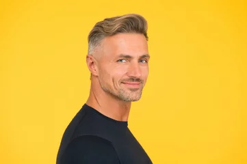  handsome unshaven man. mature macho man yellow background. male hairstyle fashion. skin facial care. hair fashion for men. barbershop concept. confident and smiling guy. portrait of charisma © be free