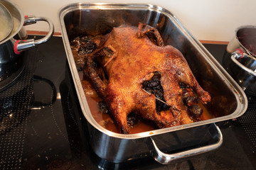 in a silver roasting pot lies a crispy brown roasted duck