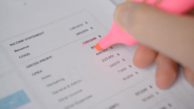 highlighting with a pink marker important financial data in the profit