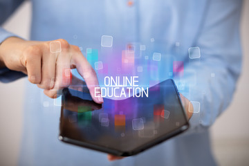 Young man holding a foldable smartphone with ONLINE EDUCATION inscription, educational concept