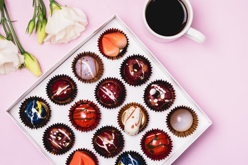 Box of Tasty Chocolate Candies Two White Flowers and Cup of Coffee Homemade Cocolate Candy Tasty and Beautiful Dessert Top View Horizontal